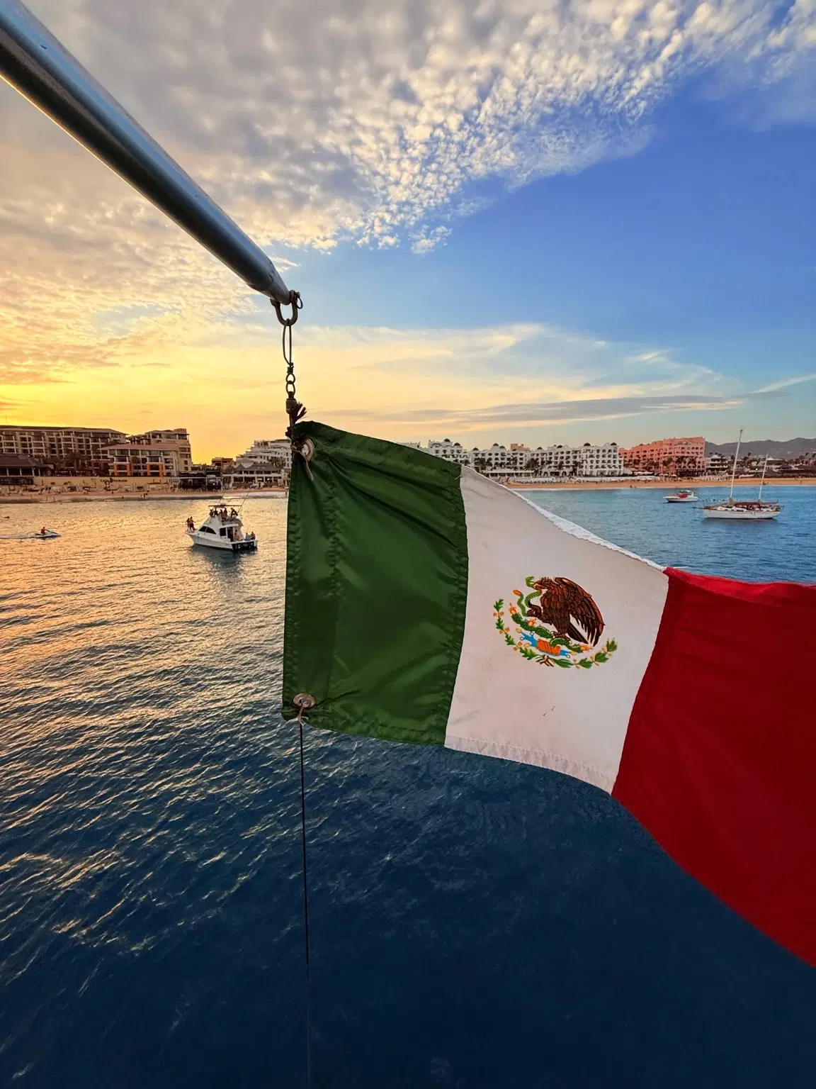 Private Cabo yacht charter with Mexican flag at sea for bachelorette celebration